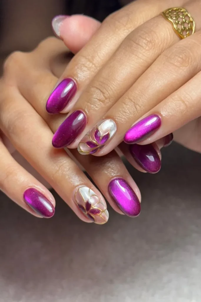 August Nails Ideas featuring glossy magenta velvet cat-eye polish with delicate 3D flower petals outlined in gold line art
