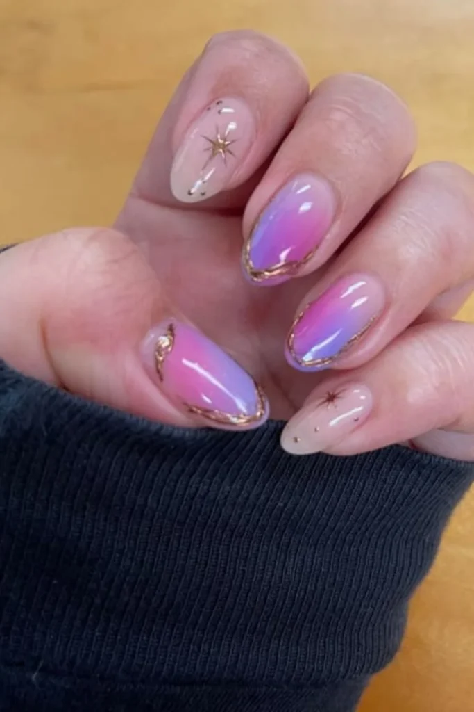Dreamy pink and purple aura nails with celestial starburst art and metallic gold rim outlines for fall transition nails ideas