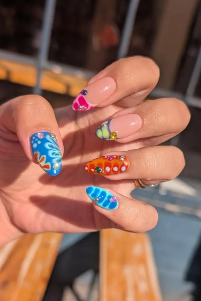 Eclectic bright colorful nail art featuring tropical patterns, gems, and 3D embellishments for vacation nails ideas