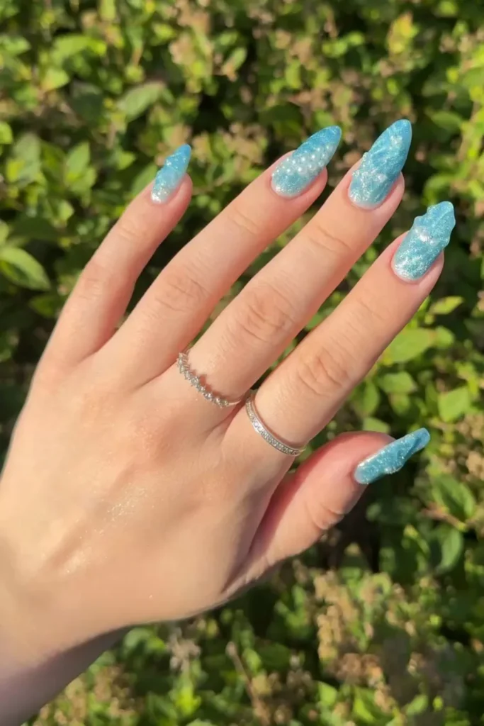 Icy light blue glitter nails featuring 3D water texture and pearl embellishments for vacation nails ideas