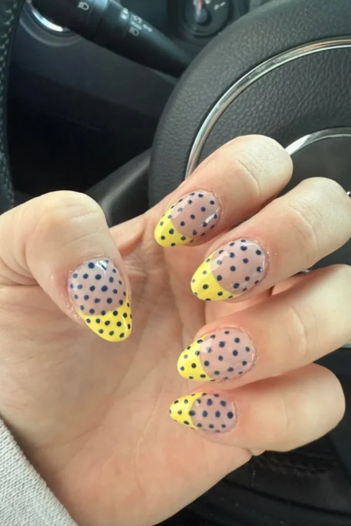 Nude oval nails with yellow French tips and black polka dot art for fall transition nails ideas
