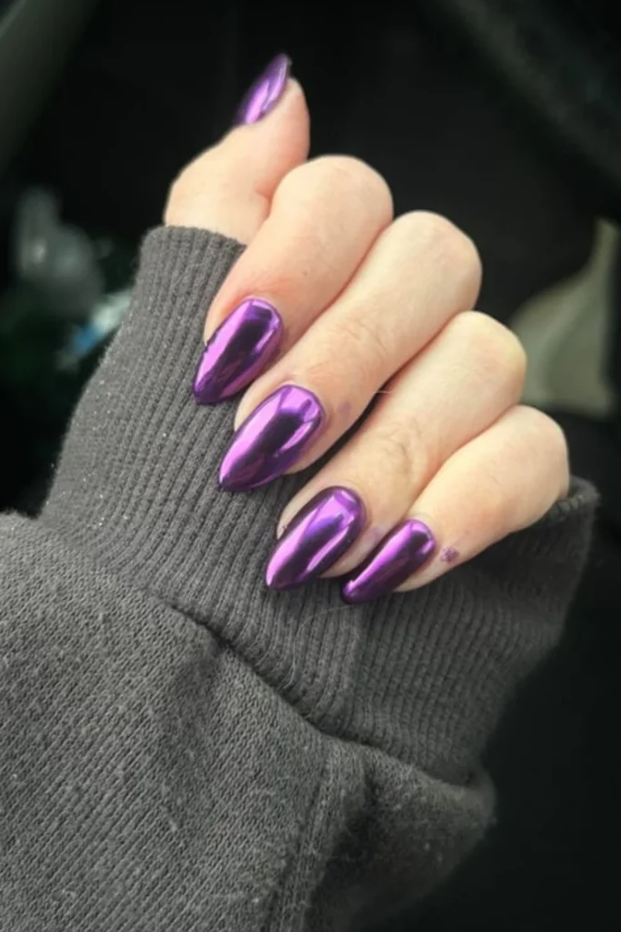 Bold September nails ideas with shiny metallic purple chrome almond nails paired with a cozy gray knit sweater cuff