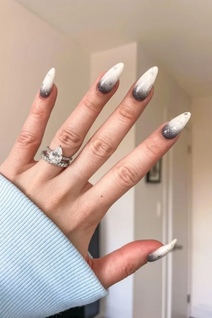 Celestial September nails ideas featuring long stiletto nails with a black-to-white ombre gradient accented by delicate silver starburst nail art