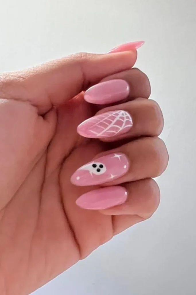 Cute ghost-themed September nails ideas featuring light pink almond-shaped nails with a white spiderweb accent and a friendly ghost nail art design
